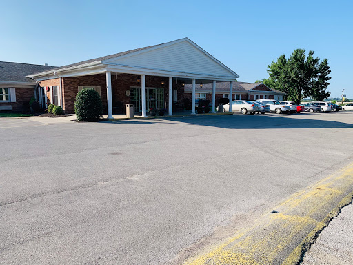 A view of a commercial building with a parking lot on a clear day.