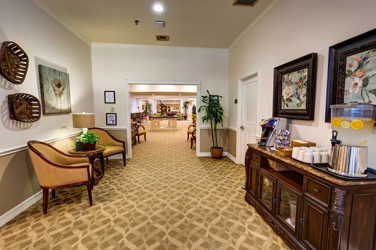 A well-decorated hallway with seating, artwork, and a potted plant.