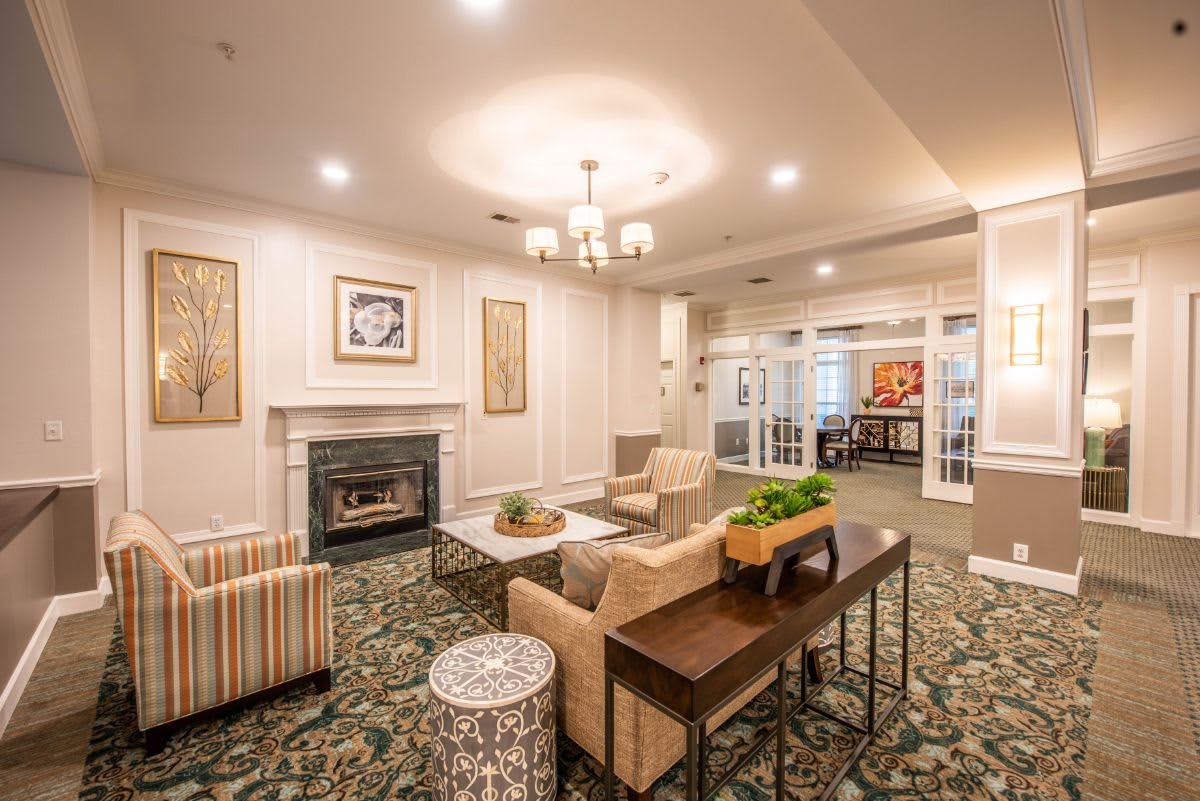A cozy living room with a fireplace, comfortable seating, and elegant decor.