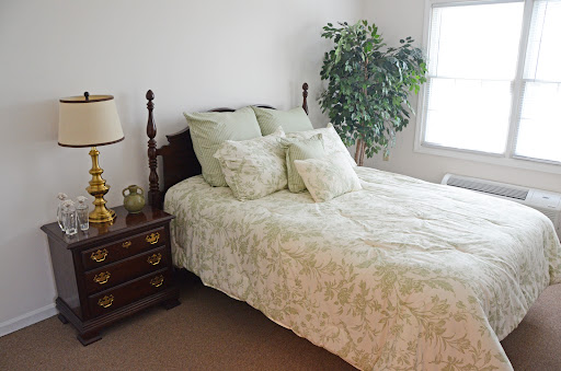 A cozy bedroom featuring a neatly made bed with floral bedding and a stylish nightstand.