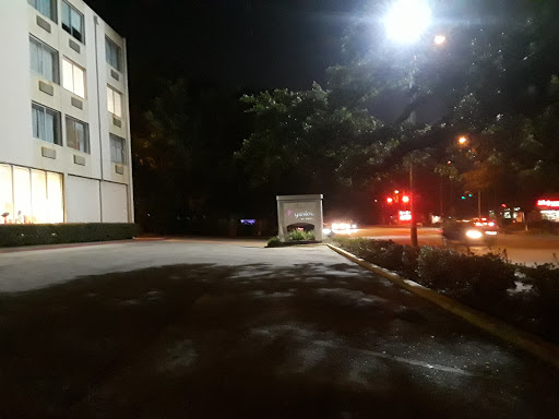 A quiet urban parking lot at night, illuminated by streetlights.