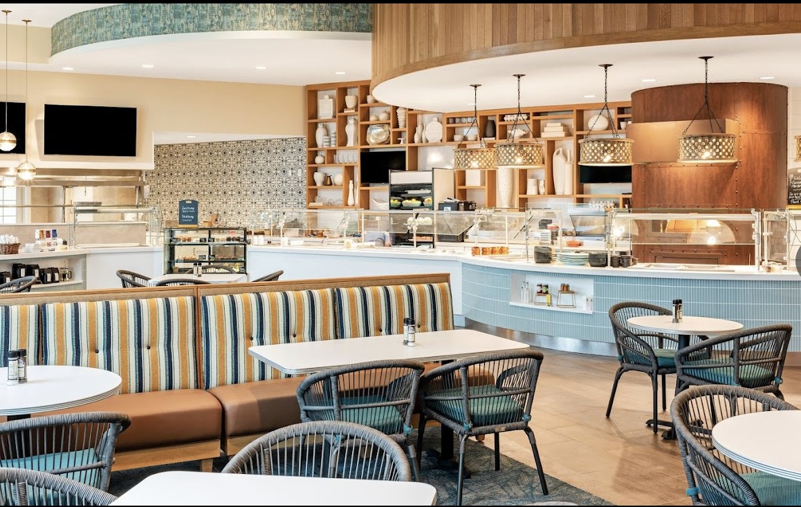 A modern cafe interior with stylish seating and a well-lit counter area.