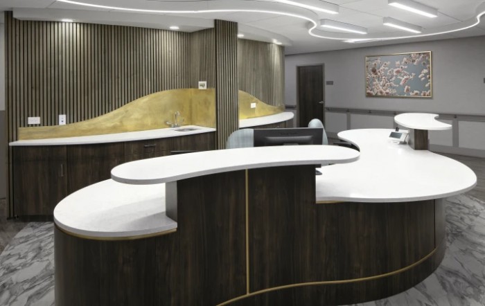 Modern reception desk with a curved design in an office setting.