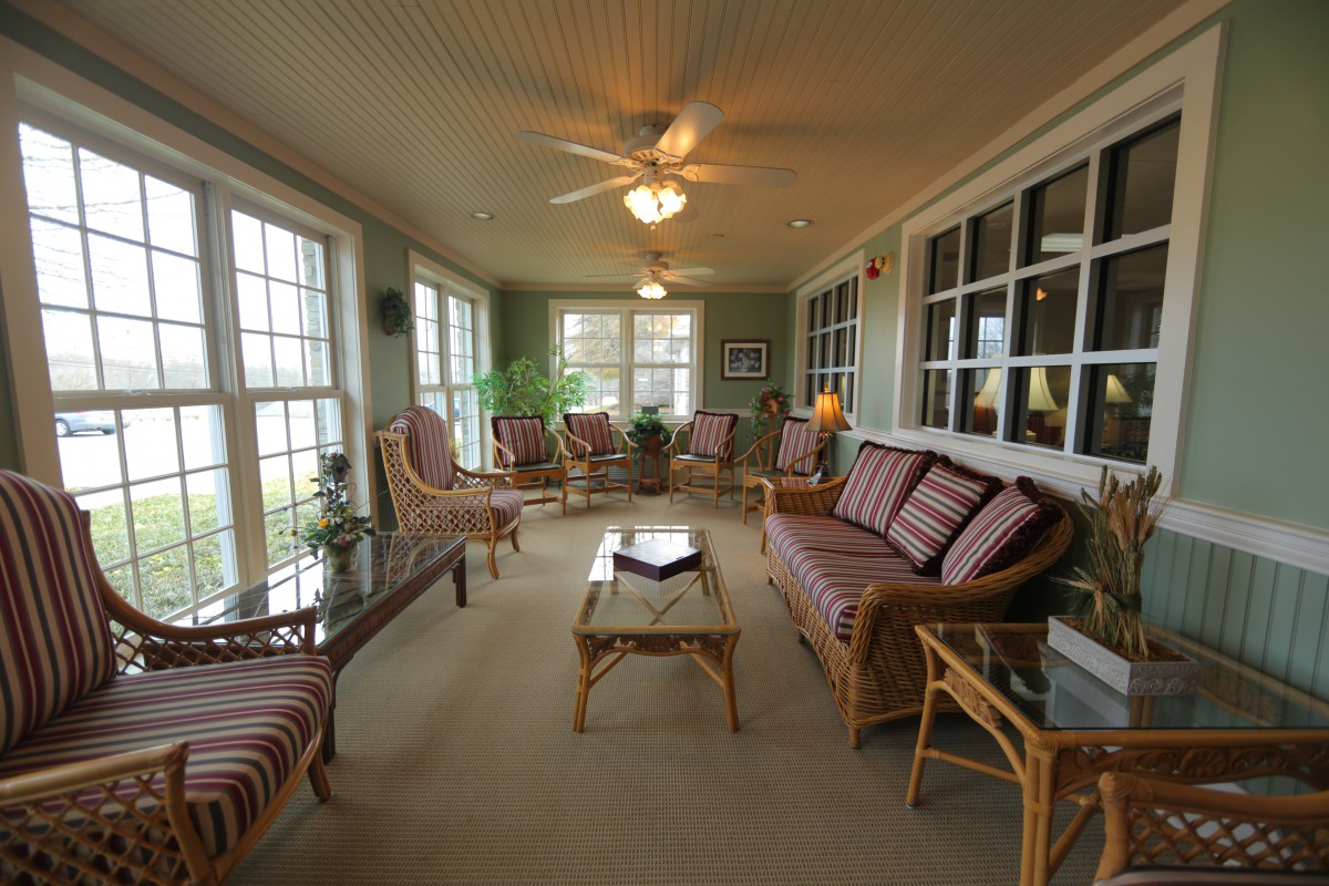 A cozy sunroom with ample seating and large windows allowing natural light to fill the space.