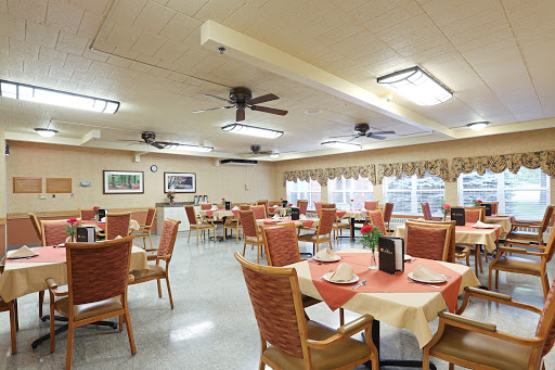 A spacious and well-lit dining area with neatly arranged tables and chairs.
