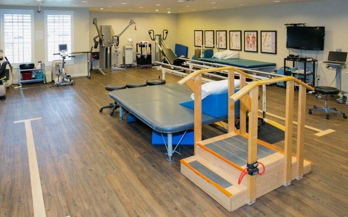 A well-equipped rehabilitation and physical therapy room with various exercise machines and equipment.