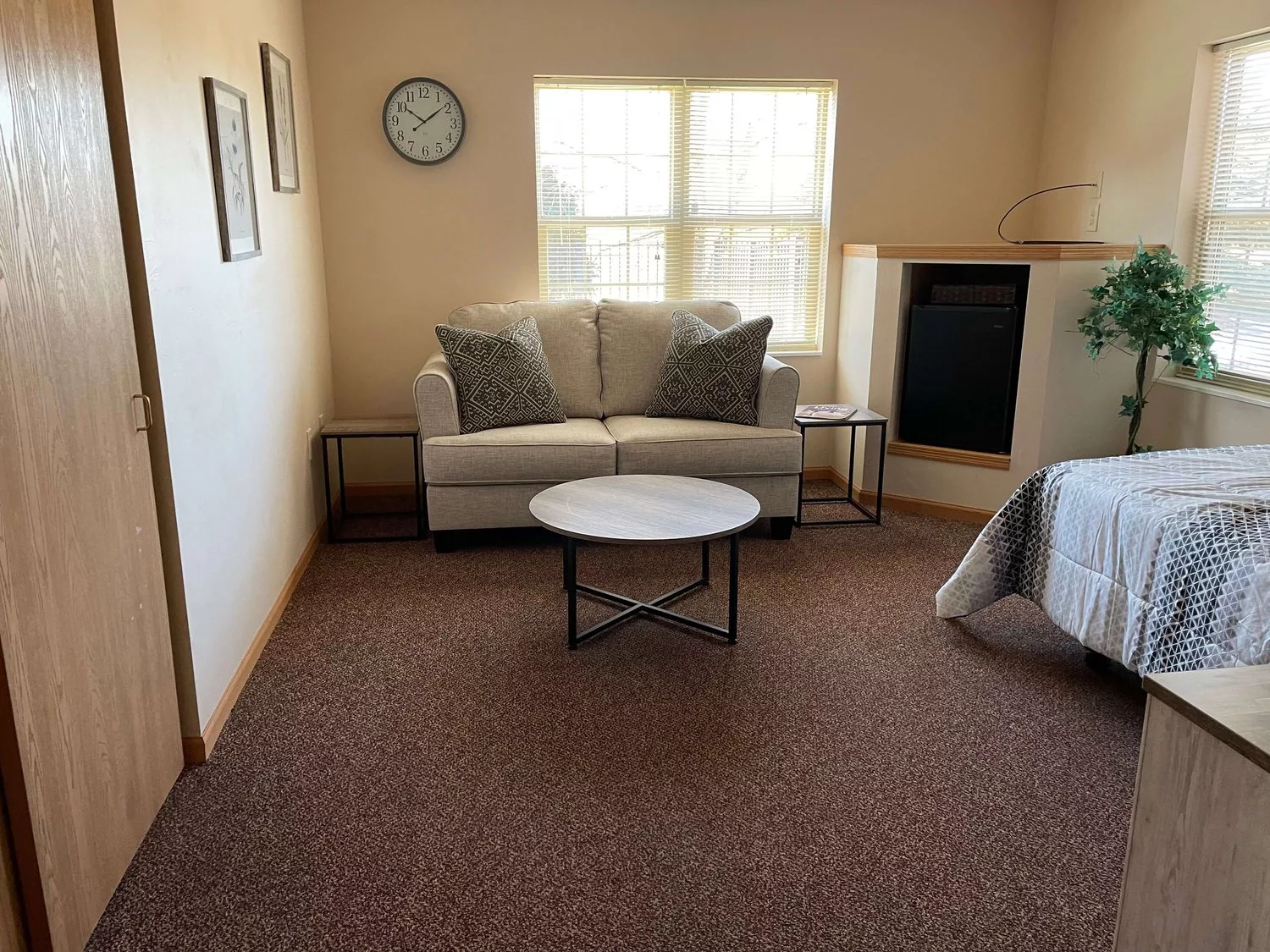 A minimalist living room with a sofa, coffee table, and wall clock.