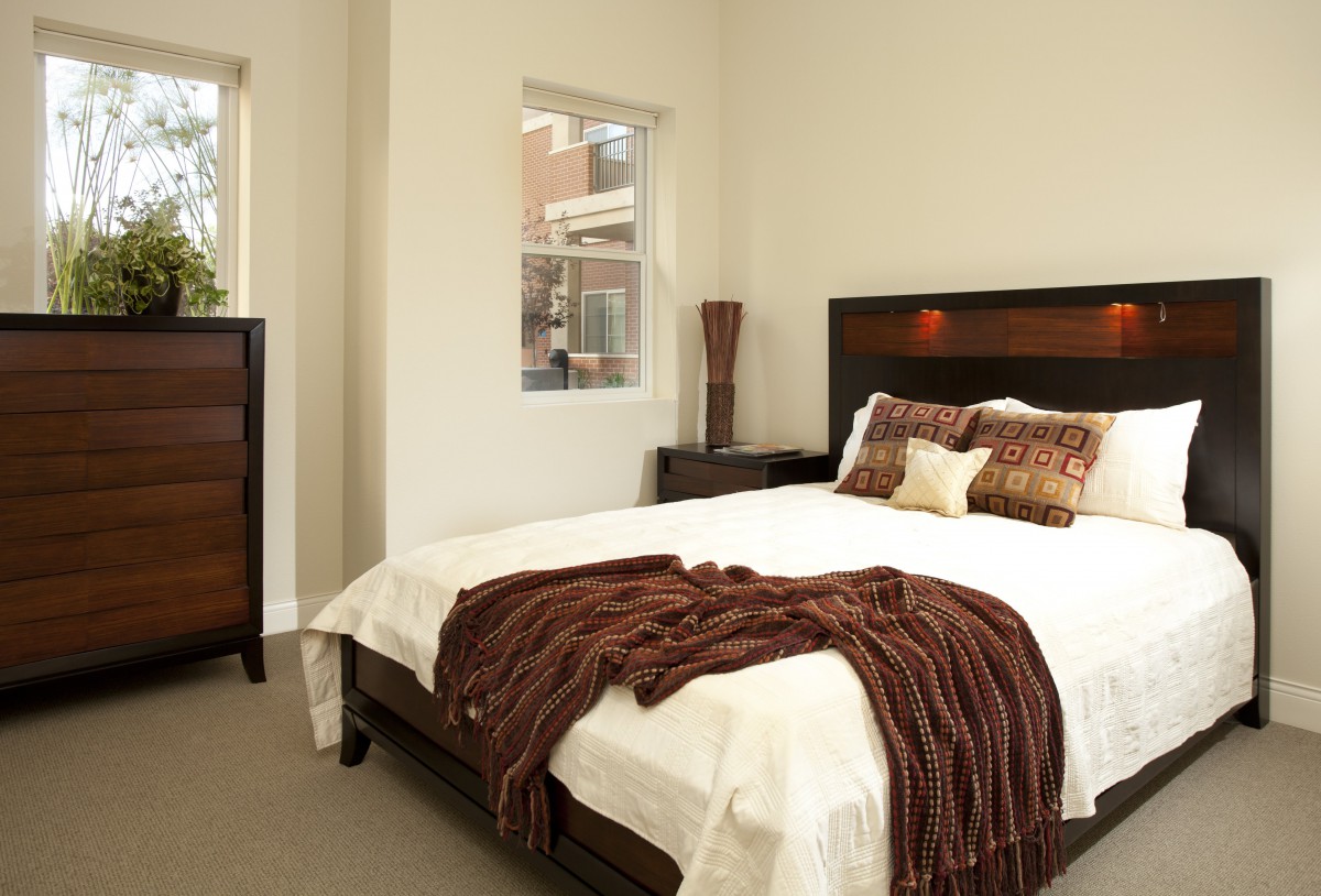A cozy and elegantly decorated bedroom with a neatly made bed, soft pillows, and a plush blanket.