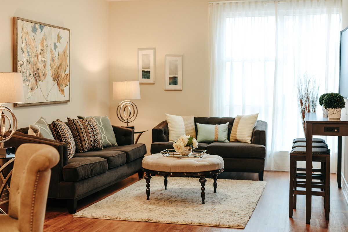 A cozy living room with stylish sofas, a round coffee table, and soft lighting.