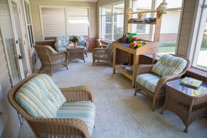 A cozy sunroom featuring wicker furniture and abundant natural light.