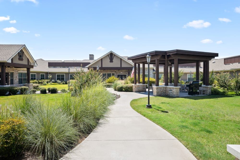 A well-maintained pathway leads to a building with a gazebo and manicured landscaping.