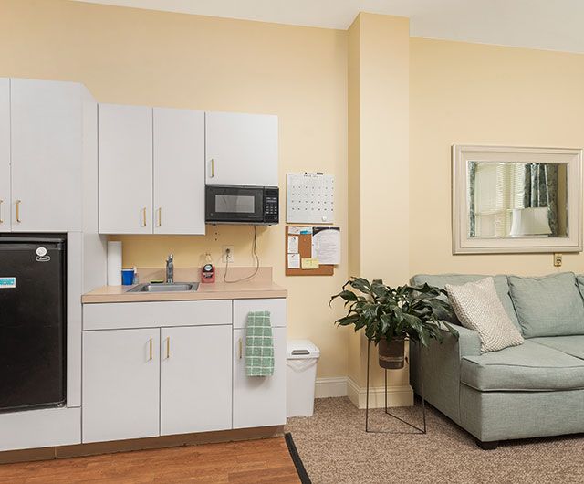 Cozy kitchenette with cabinets, a microwave, and a comfortable seating area.