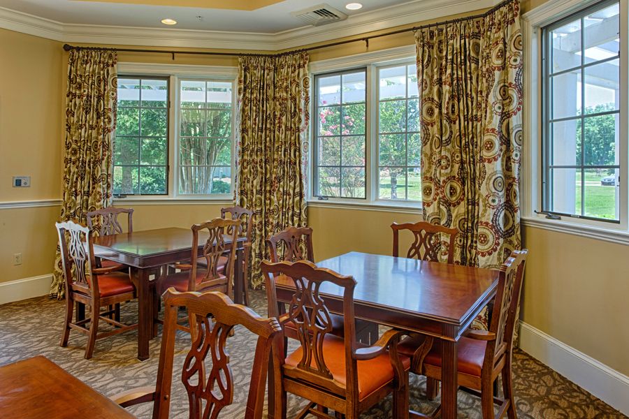 A cozy dining room with elegant wooden furniture and patterned curtains.