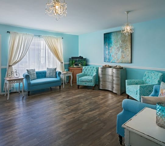 A stylish living room with blue walls, elegant furniture, and vibrant decor.
