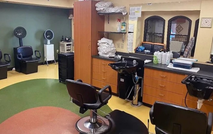 A well-equipped and organized hair salon interior with styling chairs, sinks, and salon equipment.
