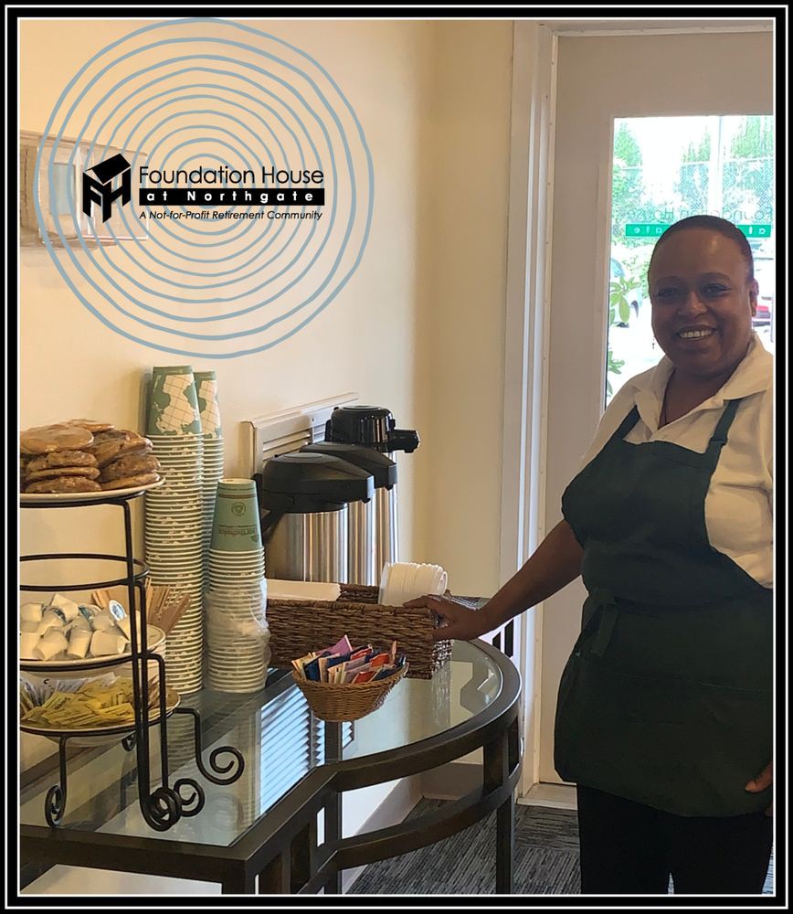 A staff member at a hospitality coffee station, ready to serve refreshments.