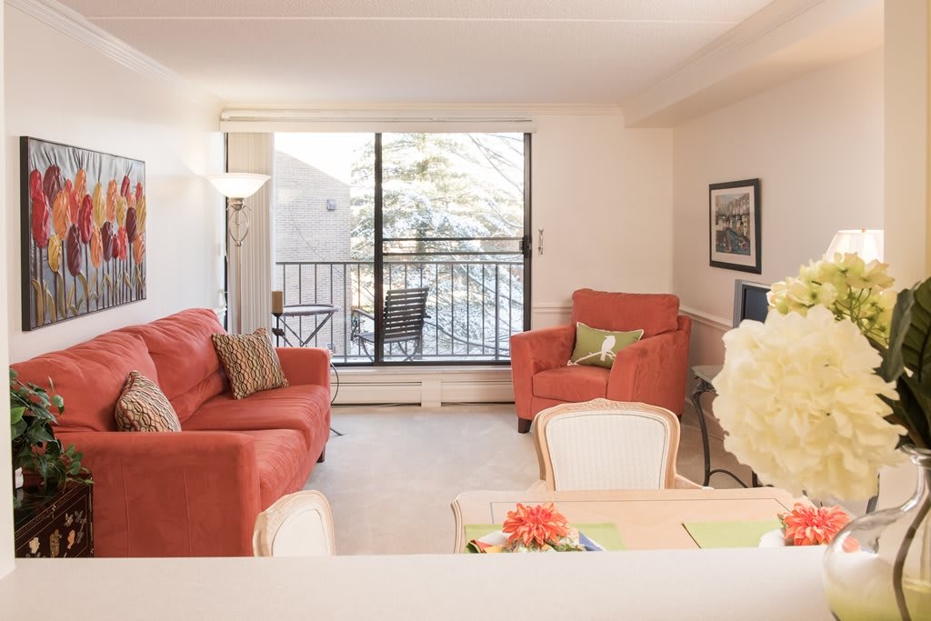 Bright and cozy living room with red sofas and a view of the balcony.