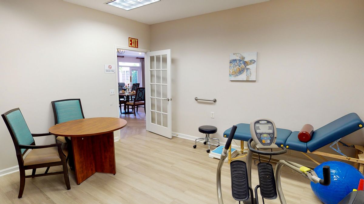 An office-style treatment room with medical equipment and furniture.
