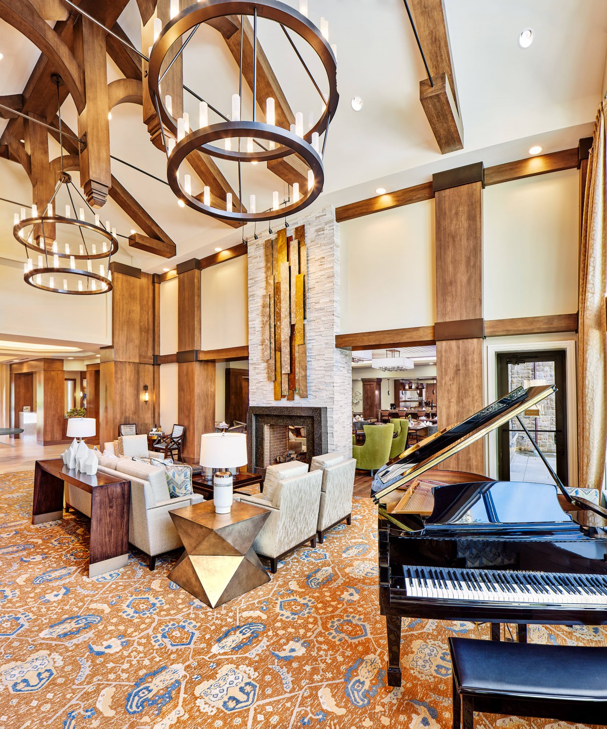 A luxurious living room with a grand piano, high ceilings, and elegant decor.