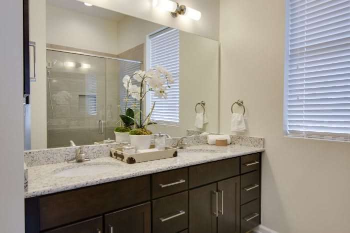 A modern bathroom with a large mirror, double sink vanity, and elegant decor.
