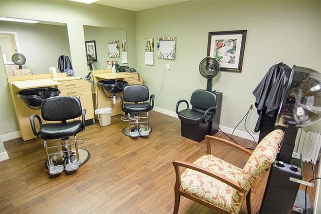A cozy salon with barber chairs, mirrors, and a waiting area.
