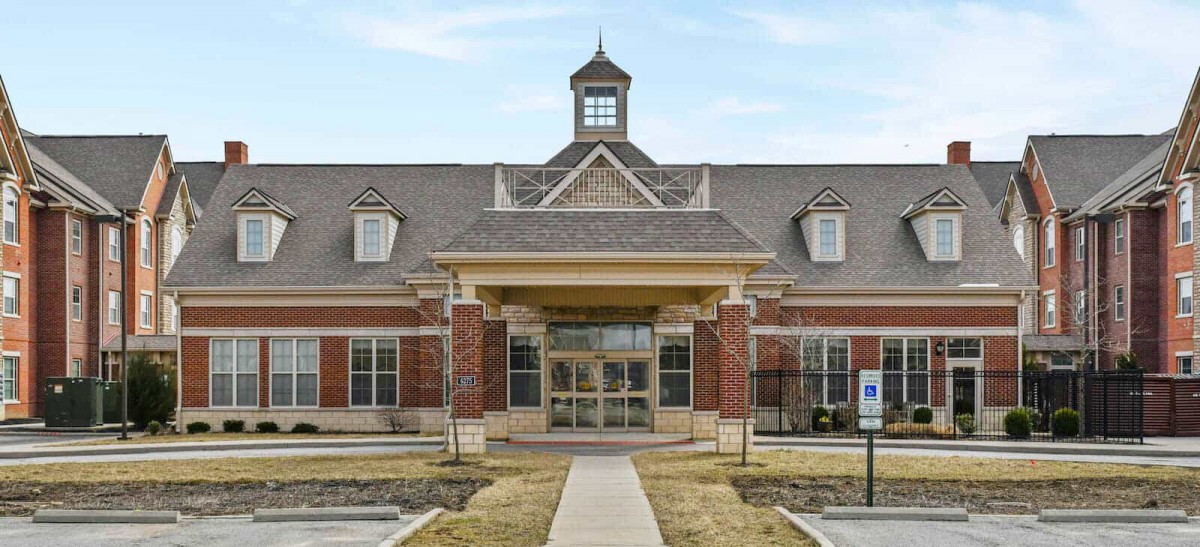 A brick building with a grand entrance and symmetrical design.