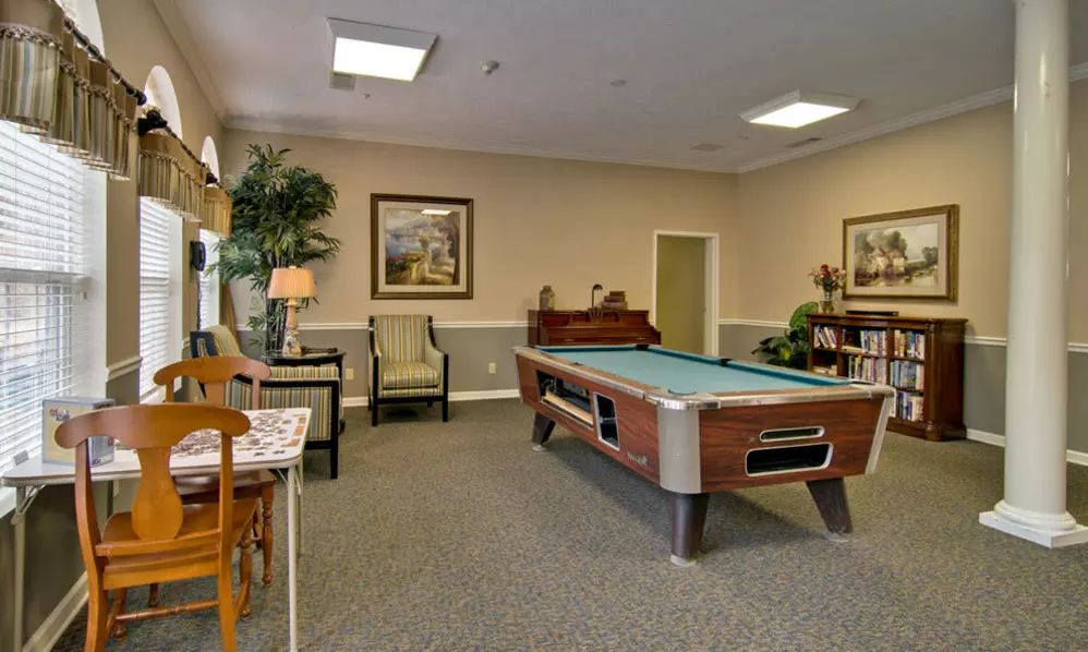 A cozy game room with a pool table and comfortable seating.