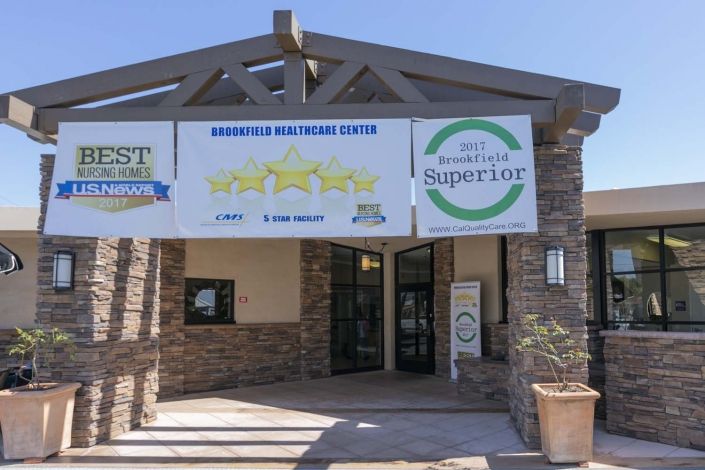 Exterior view of a healthcare center with banners displaying awards and ratings.