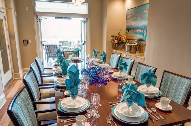 A beautifully set dining table with turquoise napkins and elegant decor, ready for a formal dinner.