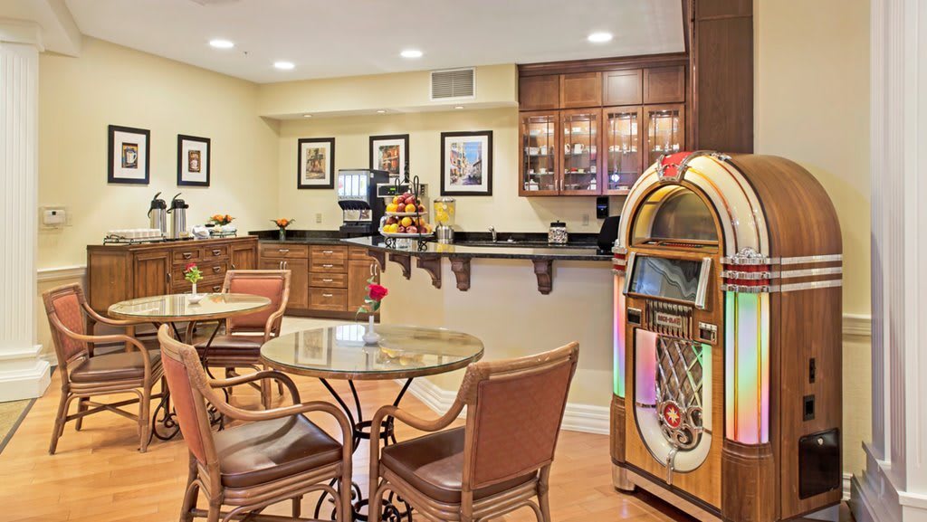 A cozy cafe with a jukebox, seating area, and counter.