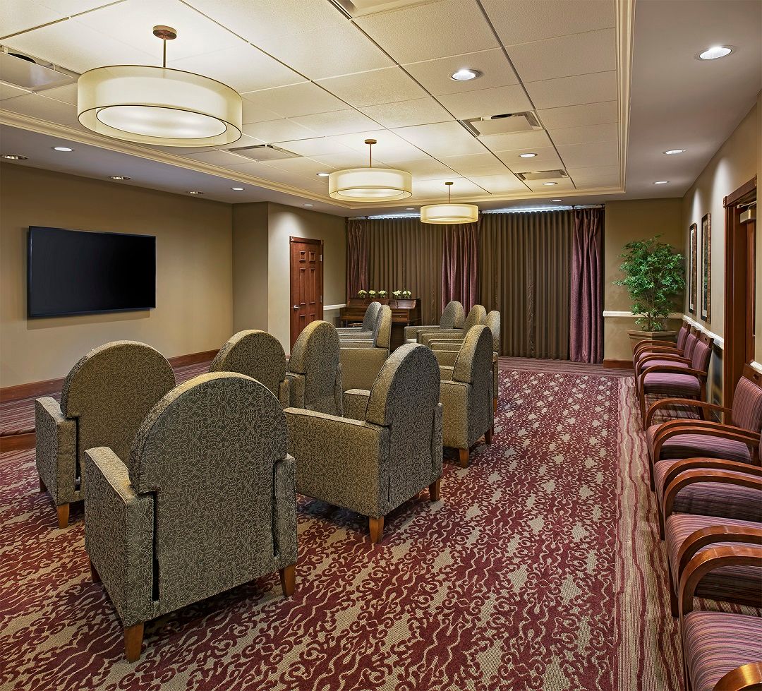 A well-arranged conference room with comfortable seating and a large television.