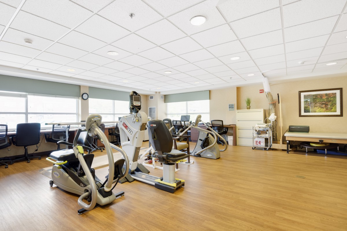 A spacious gym with various exercise machines and stationary bikes.
