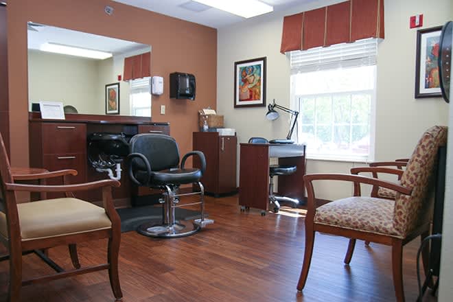 A well-furnished hair salon with barber chairs, mirrors, and a waiting area.