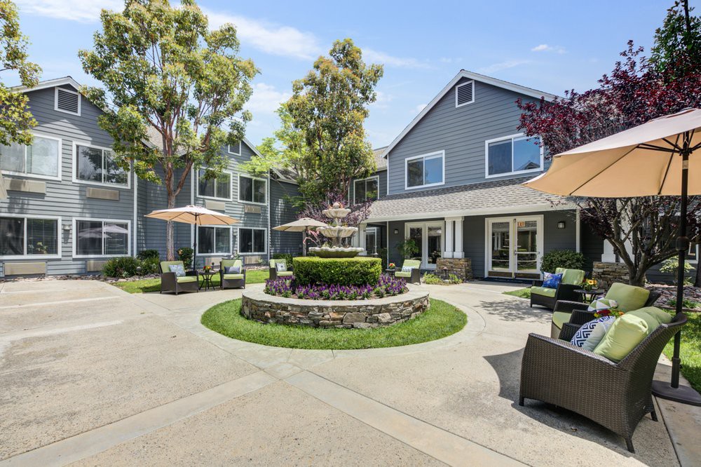 A charming residential courtyard with a central fountain and outdoor seating.