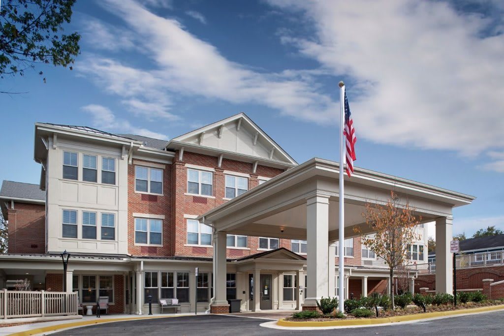A hotel building with an entrance canopy and an American flag flying.
