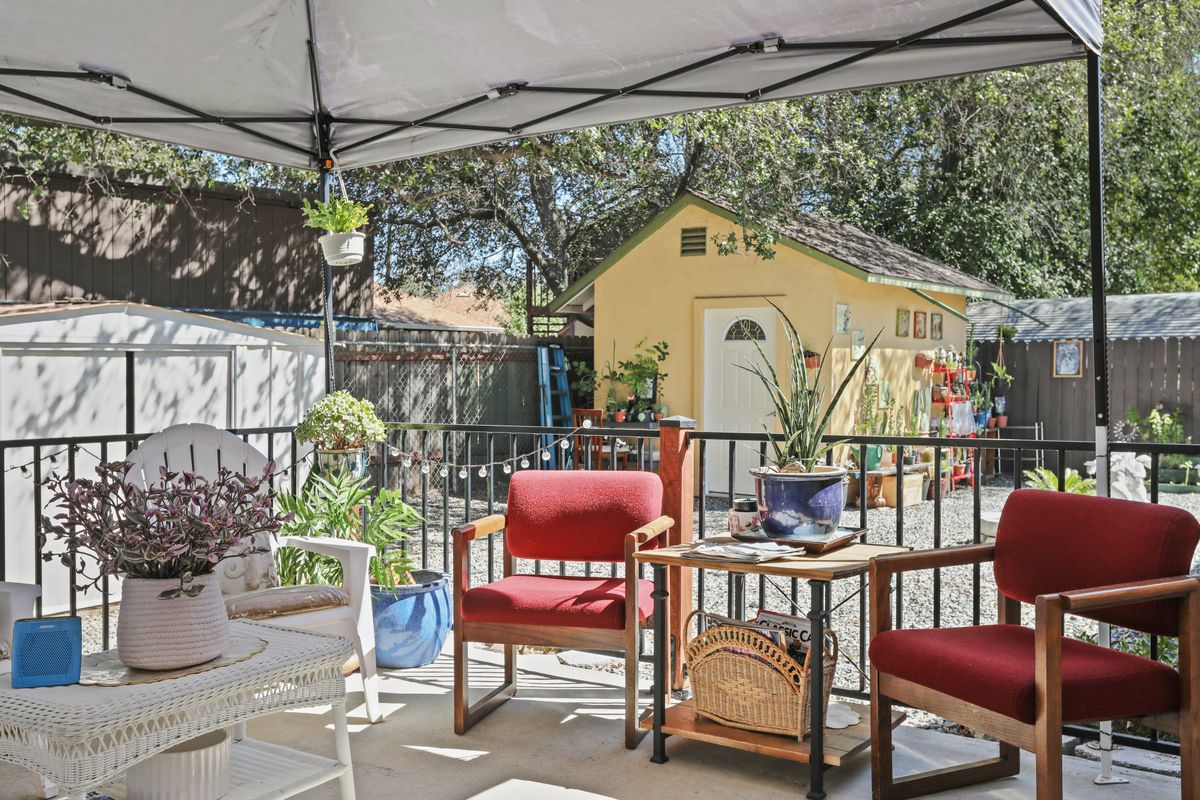 A cozy patio setup with red chairs and a garden view.