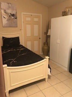 A cozy bedroom with a single bed and a large wardrobe.