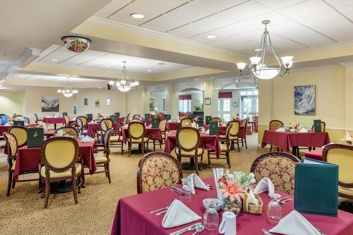 An elegantly decorated dining room with neatly arranged tables and chairs.