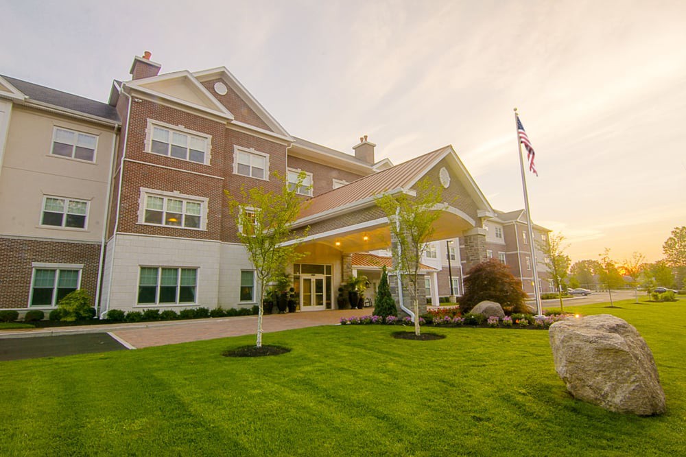 A large building with a well-maintained lawn and an American flag at sunset.