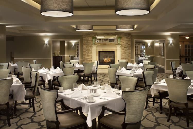An elegant restaurant dining room with beautifully set tables and a cozy fireplace.