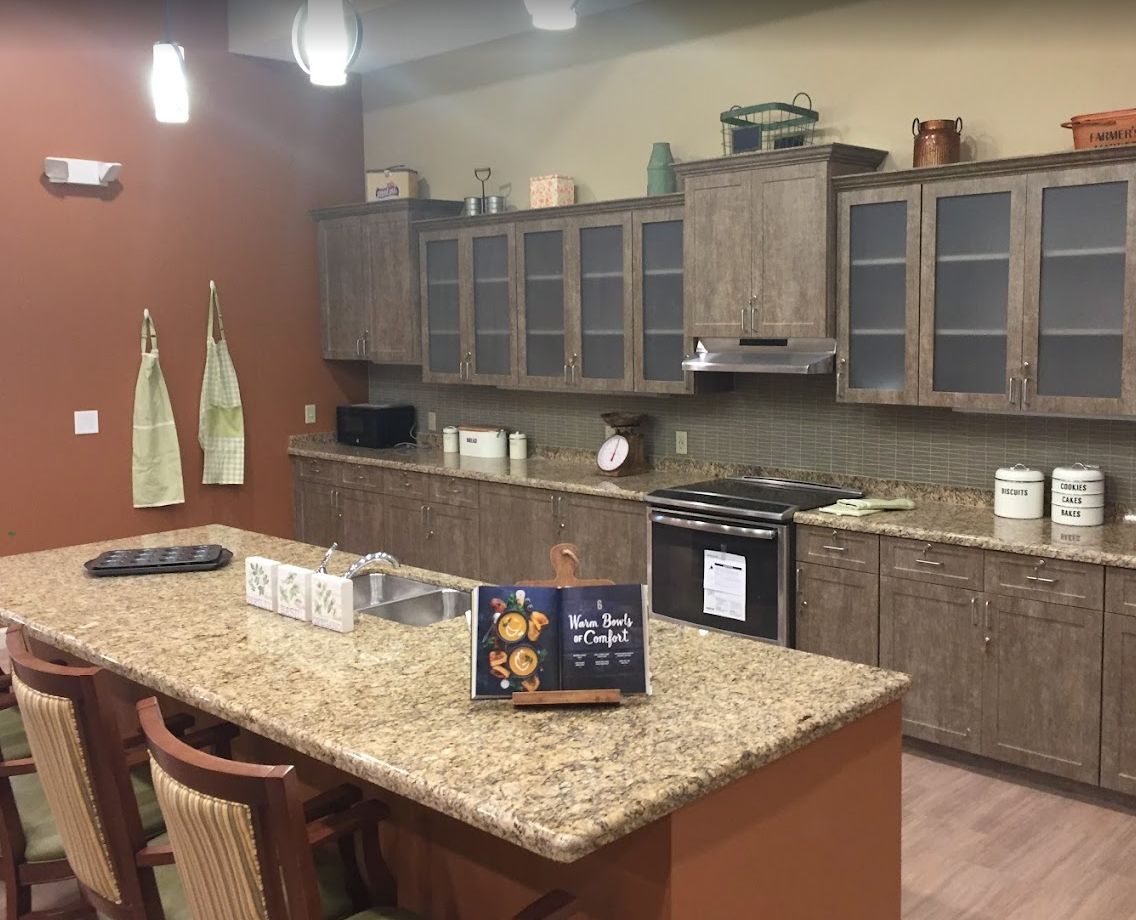 A modern kitchen with granite countertops and wooden cabinets.