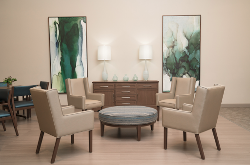 A stylish seating area featuring modern chairs, a round table, and elegant wall art.