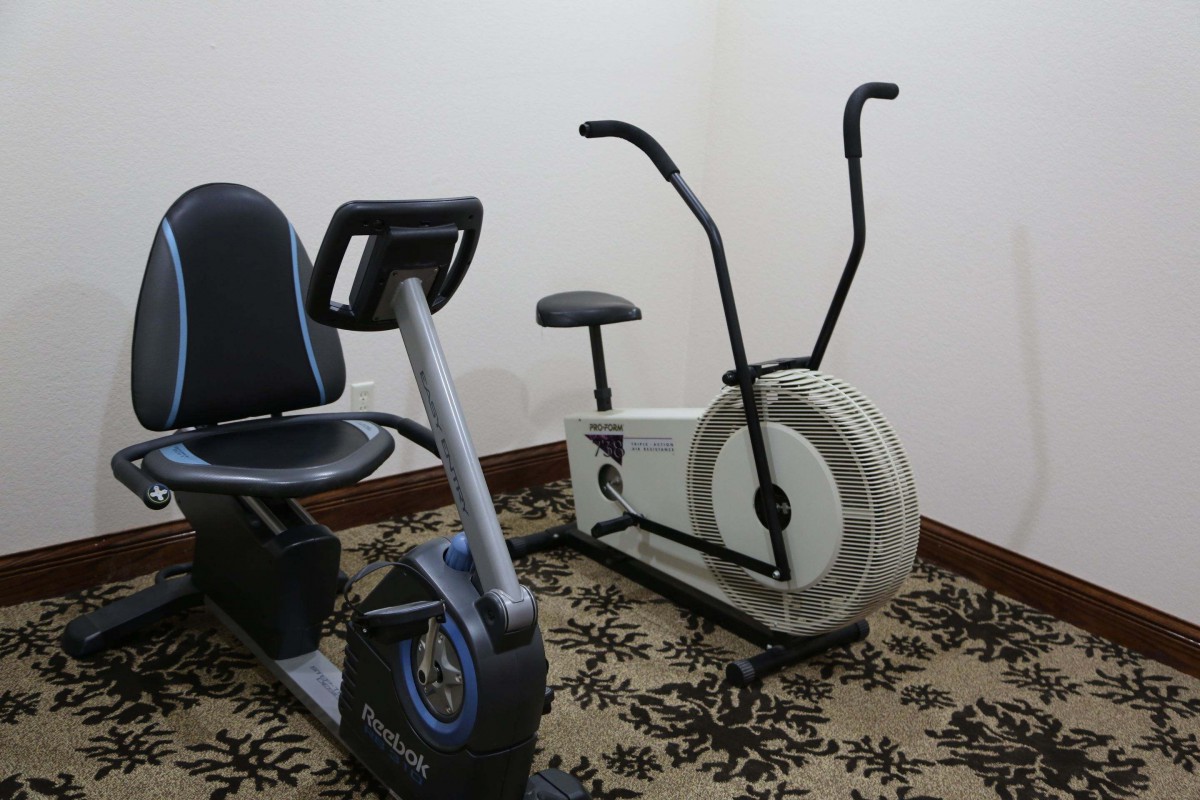 A room with two types of stationary exercise bikes for indoor workouts.