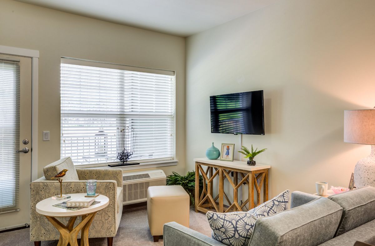 A cozy modern living room with comfortable seating and a mounted TV.