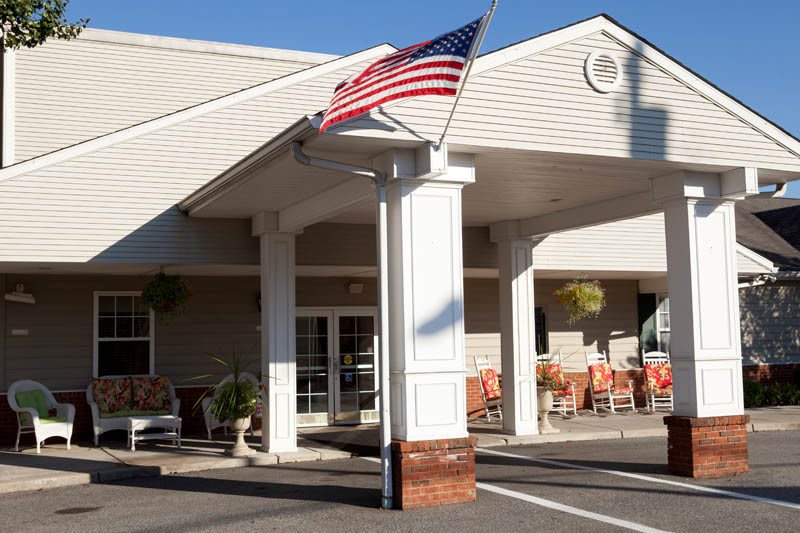 The entrance of a building with an American flag displayed.