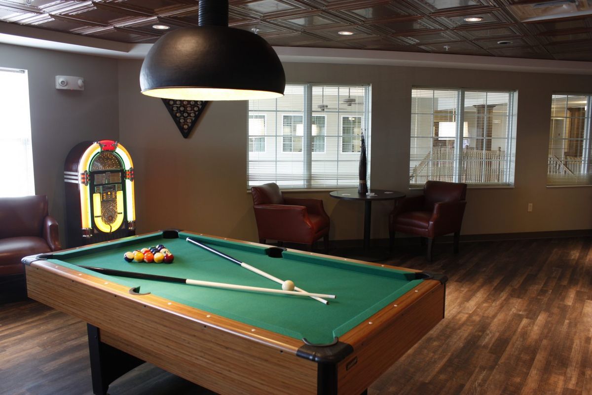 A cozy lounge area featuring a pool table and a vintage jukebox.