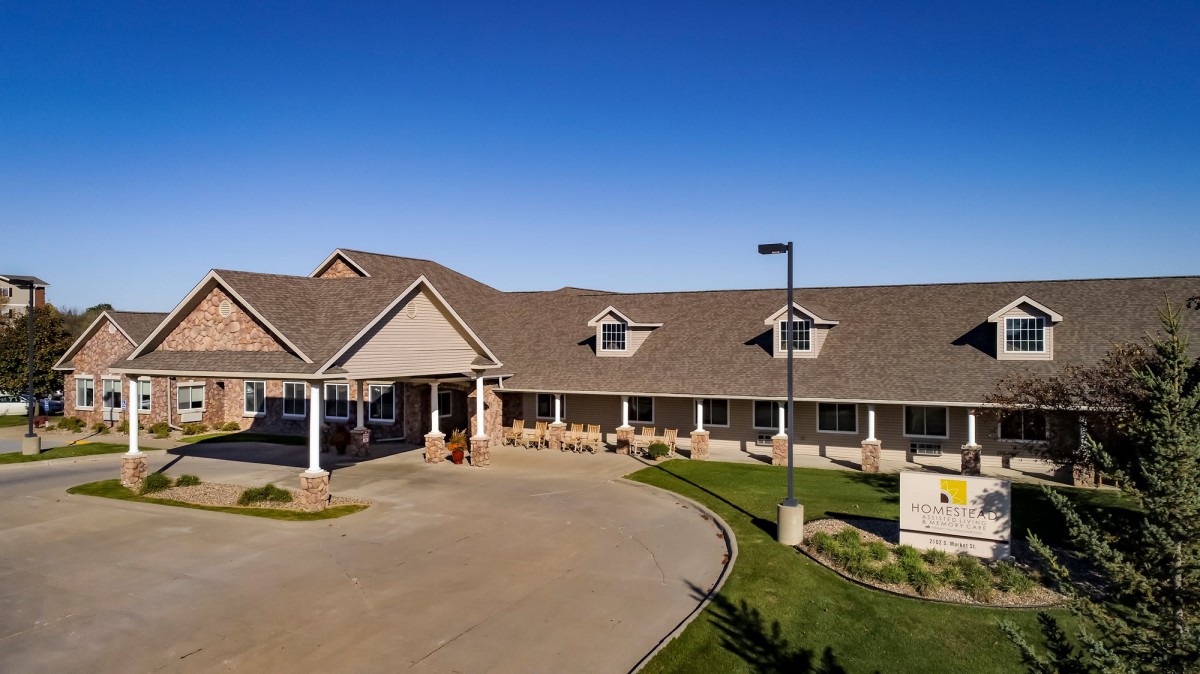 A suburban residential building with a well-maintained driveway and landscaping.