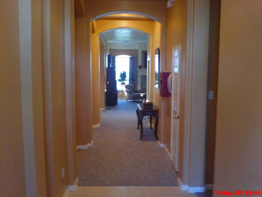 A warm, inviting hallway leading to a well-lit room.