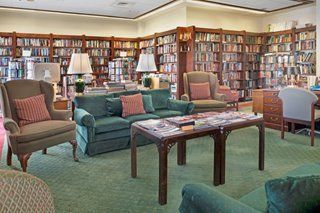 A cozy library room with bookshelves and comfortable seating.