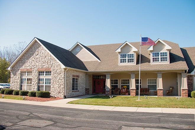 A suburban house with a spacious lawn and an American flag.